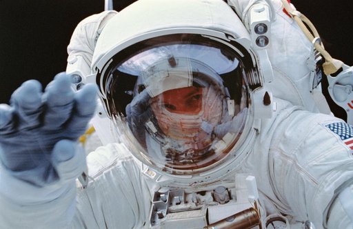 EVA-1 Crewmember Greg Harbaugh (red stripe) working in payload bay.
