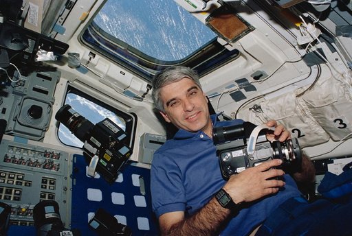 Astronaut Sidney Gutierrez on flight deck holding Hasselblad camera