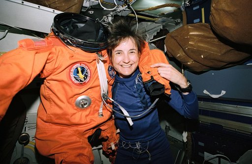 Astronaut Linda Godwin poses with spacesuit she wore for launch