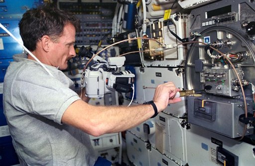 Astronaut Joseph R. Tanner works with PCG experiment on middeck