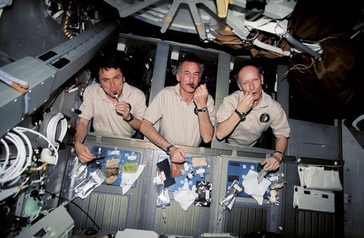 Astronauts Chang-Diaz, Hoffman and Nicollier eating in their sleep racks