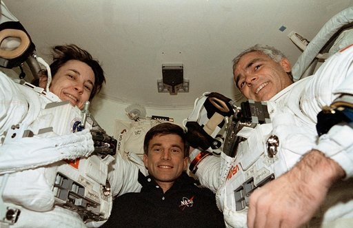 Linda Godwin and Michael "Rich" Clifford are assisted out of their EMU suits
