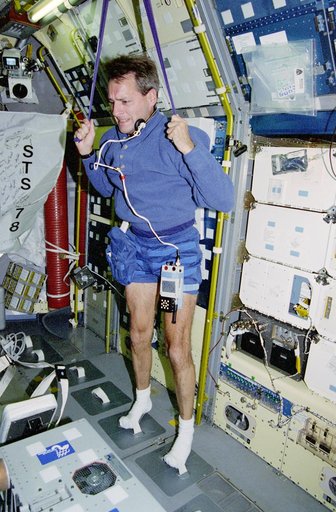 Linnehan exercises with a bungee strap in the Spacelab module
