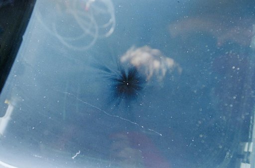Views of the overhead flight deck window showing debris impact damage