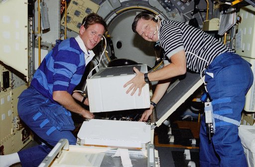 Crouch and Gernhardt unpack items from Spacelab center aisle