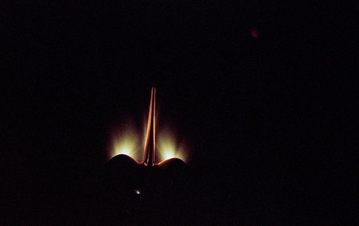 View of OMS burn and illuminated orbiter stabilizer