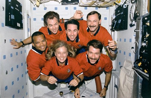 STS-85 crew portraits in the middeck hatch and in front of lockers