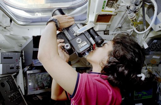Chawla poses in front of flight deck windows