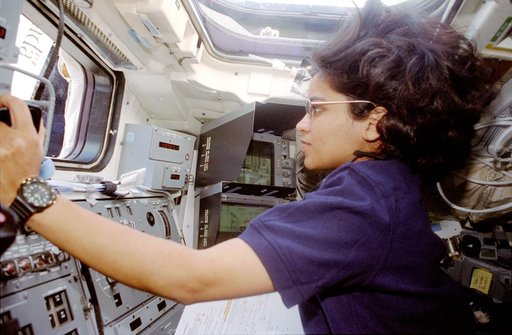 Chawla is photographed at the aft flight deck station controlling the RMS