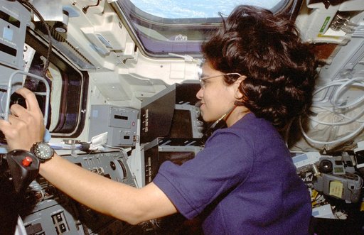Chawla is photographed at the aft flight deck station controlling the RMS