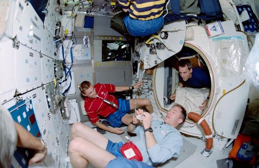 Fish-eye view of Williams, Searfoss and Pawelczyk on middeck during meal