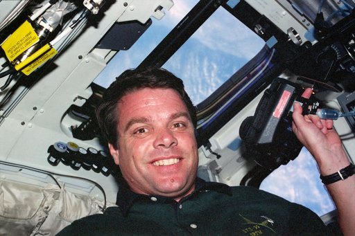 STS-99 Commander Kregel poses with EARTHKAM camera on OV-105's flight deck