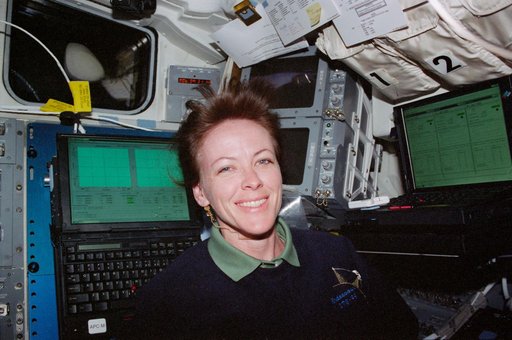 STS-99 MS Kavandi poses by two laptop computers on OV-105's flight deck