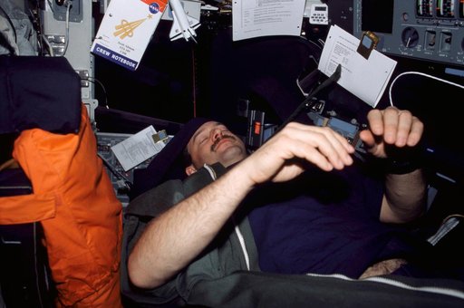 CDR Altman in sleep restraint on flight deck