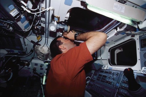 STS-109 CDR Altman on aft flight deck with binoculars