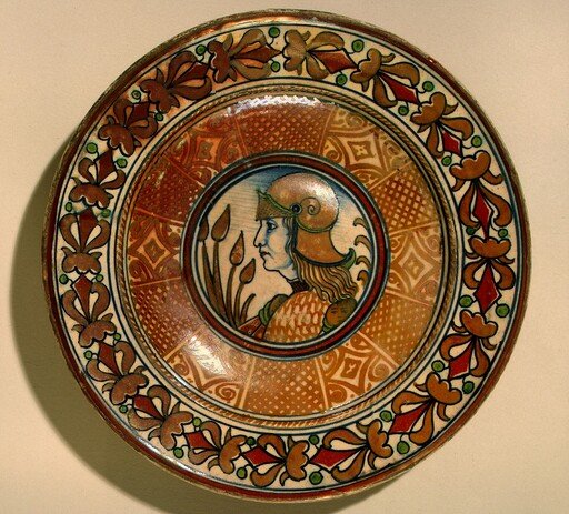 Plate with running plant border and geometric panels on well; in the center, profile bust of a man in armor