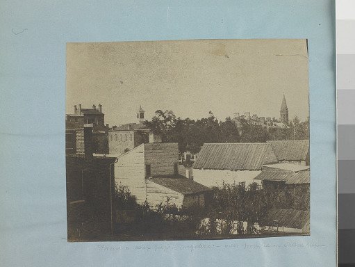 Rooftops, buildings, houses with chimneys and a steeple