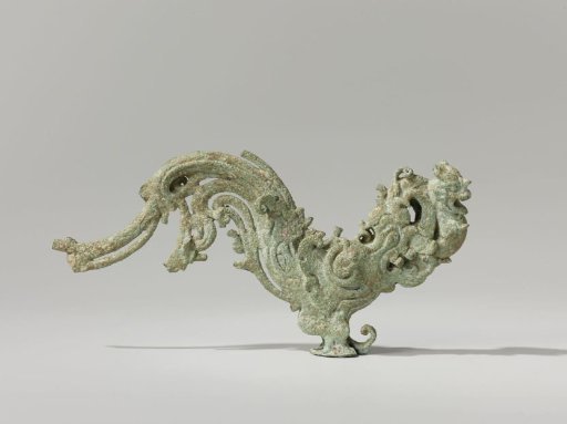 Bird with a curled tail and a lion cub in its beak