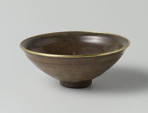 Tea bowl with a grey brown glaze and a metal rim