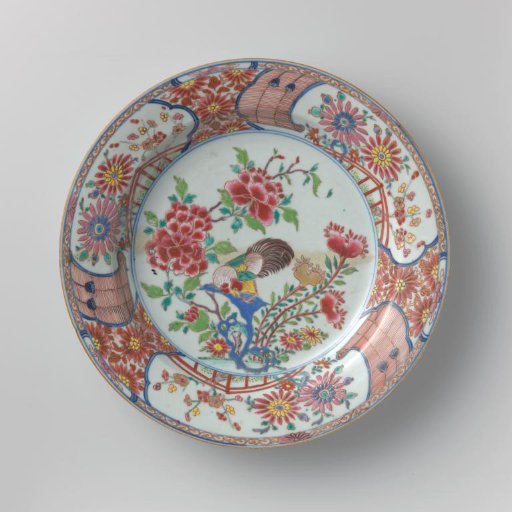 Dish with a cock on a rock near flowering plants