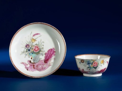 Bell-shaped cup and saucer with a snailornament and flowering plants