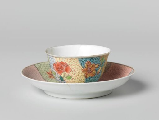 Bell-shaped cup and saucer with three flower sprays on multi-colored diaper-pattern