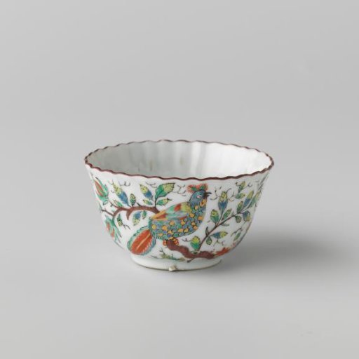 Bell-shaped cup with fluted sides with two birds on flower sprigs near a rock