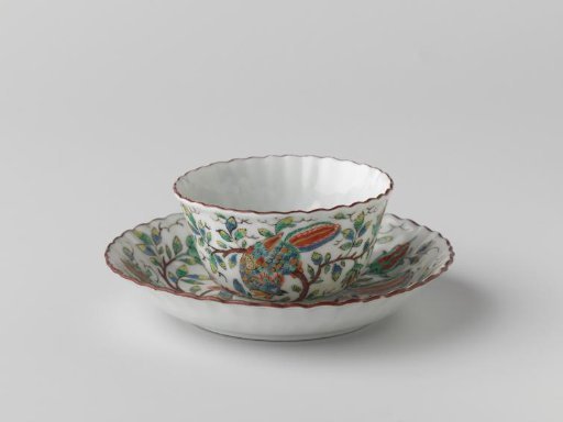 Bell-shaped cup and saucer with fluted sides with two birds on flower sprigs near a rock