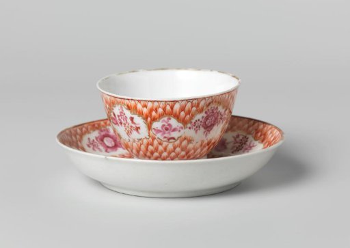 Bell-shaped cup and saucer with flower sprays in panels on a feather of scale ground