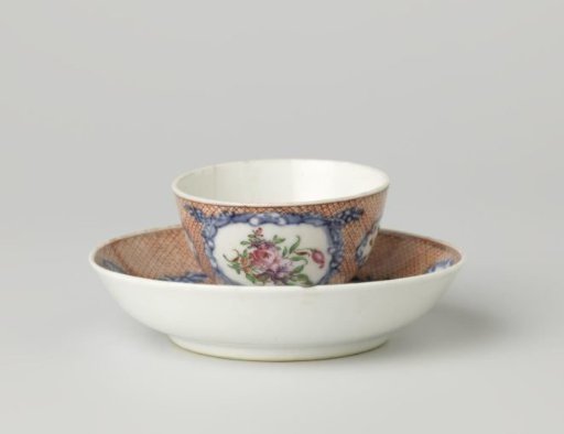 Cup and saucer with flower sprays in panels on a ground of red diaper pattern