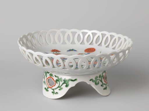 Saucer-dish on tripod with flowering plants near rocks