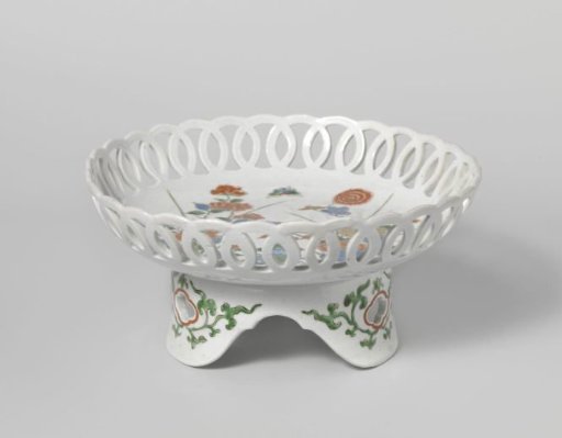 Saucer-dish on tripod with flowering plants near rocks