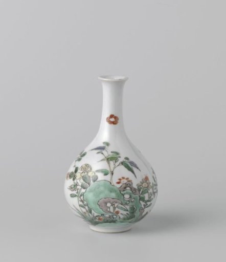 Bottle vase with flowering plants near a rock