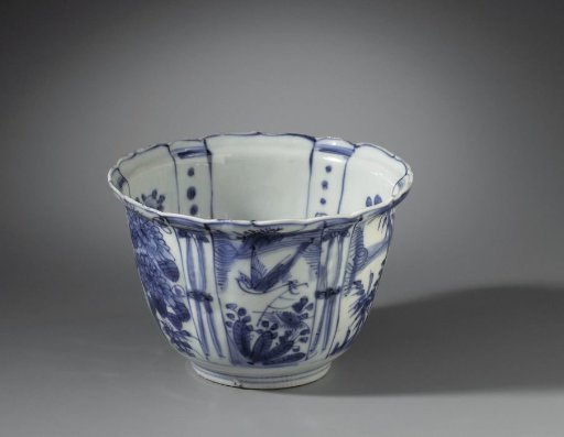 Bowl (crow cup) with flowering plants, flying birds and a bird on a rock