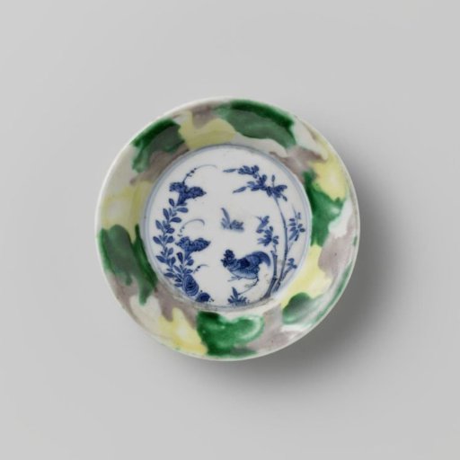 Saucer with 'egg and spinach' pattern and cock among plants
