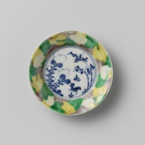 Saucer with 'egg and spinach' pattern and cock among plants