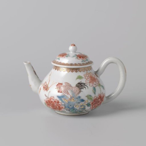 Teapot with a cock on a rock near flowering plants