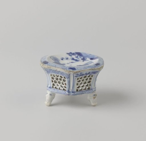 Hexagonal salt cellar with two cocks near flowering plants and pierced sides