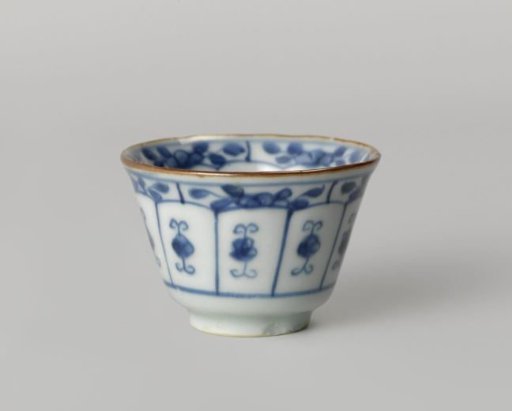 Bell-shaped cup with flowering plants, a rock and stylized flower sprays