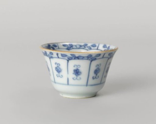 Bell-shaped cup with flowering plants, a rock and stylized flower sprays