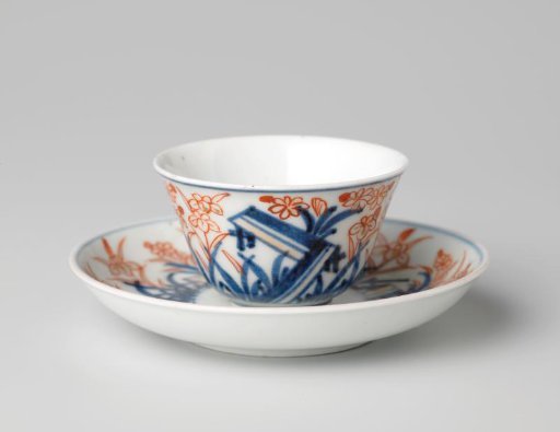 Bell-shaped cup and saucer with a flower spray and flowering plants
