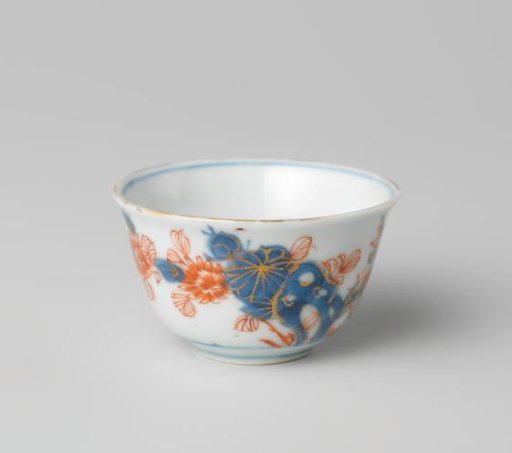 Cup with butterflies and flowering plants near a rock