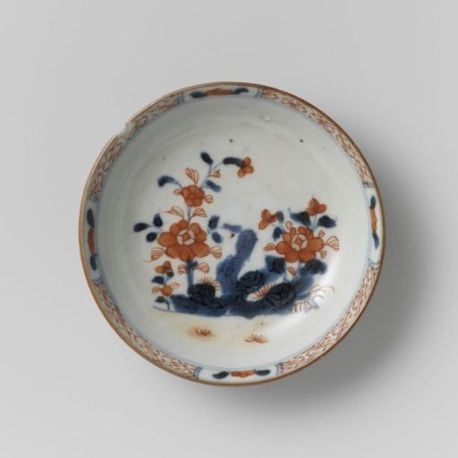 Saucer with flowering plants near a rock