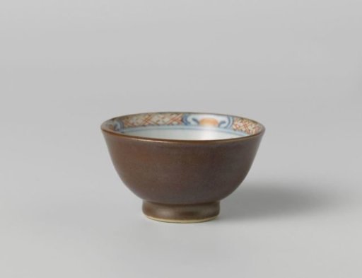 Cup with flowering plants near a rock