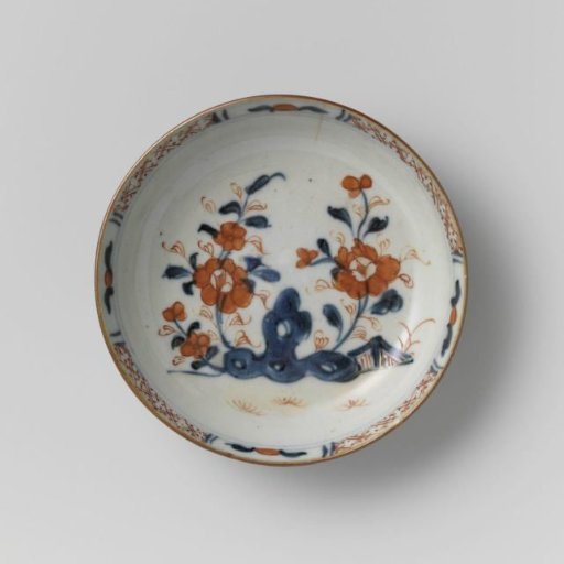 Saucer with flower sprays near a rock and a dark brown glaze