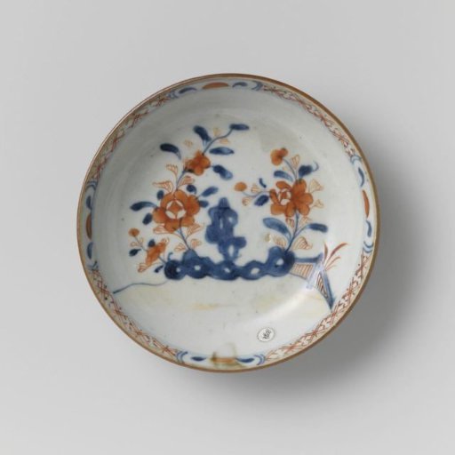 Saucer with flower sprays near a rock and a dark brown glaze