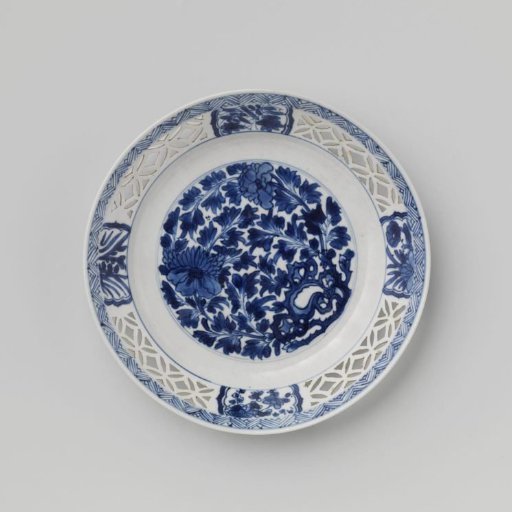 Plate with flowering plants near a rock and pierced rim