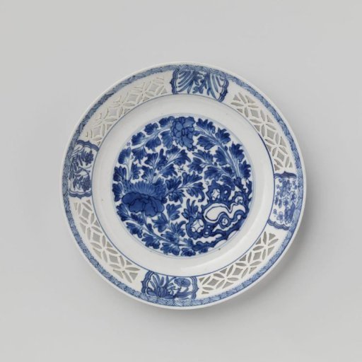Plate with flowering plants near a rock and pierced rim