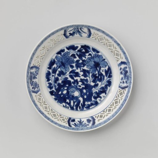 Plate with flowering plants near a rock and pierced rim