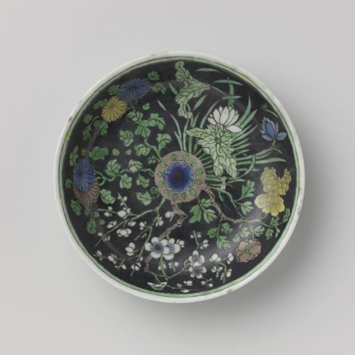 Saucer with flowering plants on a black ground